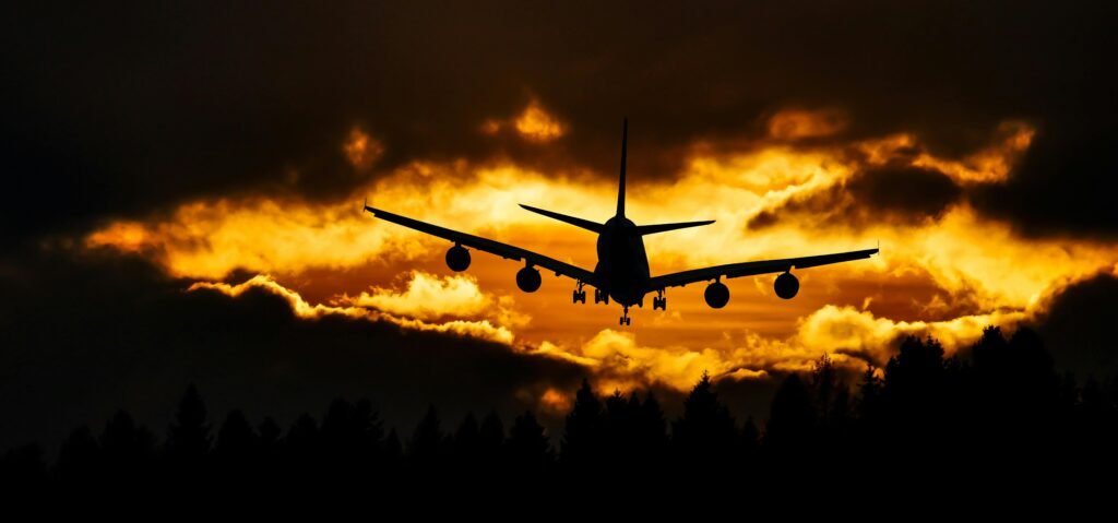 Airplane flying over clouds representing travel in the PIO Card Complete Guide for NRIs 2025
