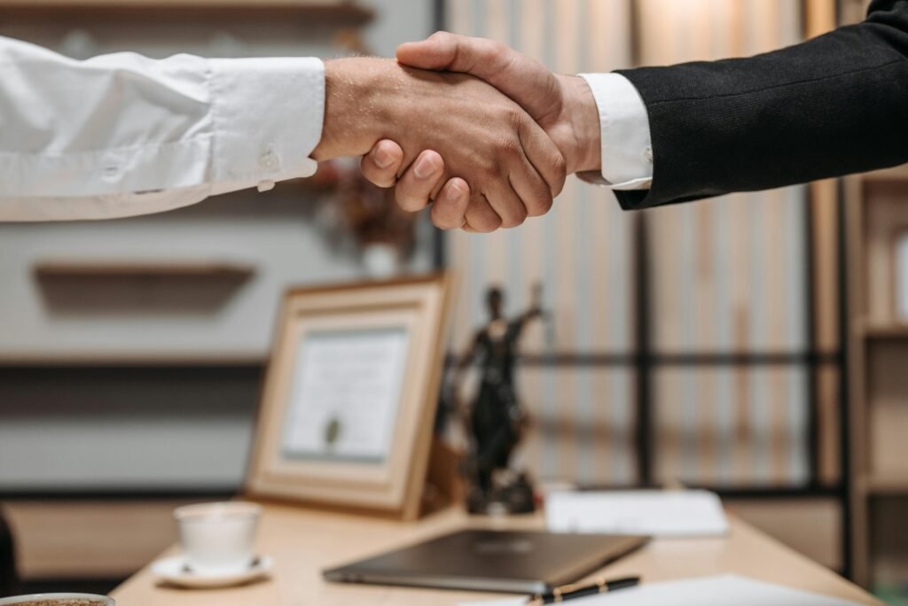 Close-up of a professional handshake representing trust and agreement, illustrating Everything NRIs Should Know About Power of Attorney.
