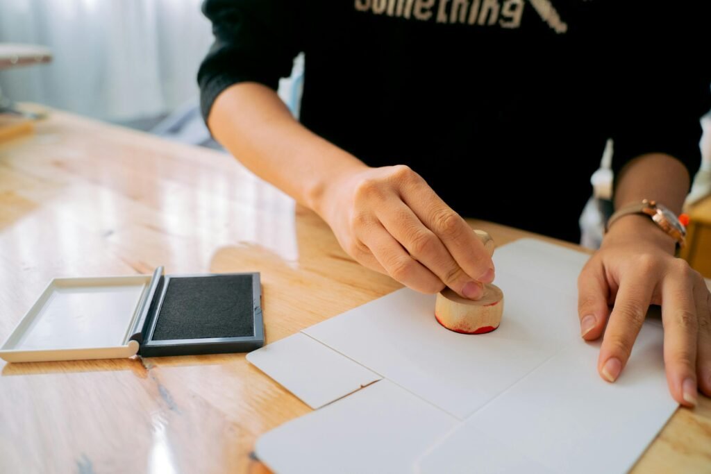 Close-up of a hand using a stamp on documents, symbolizing the apostille process — What Is Apostille? A Complete Guide for NRIs.